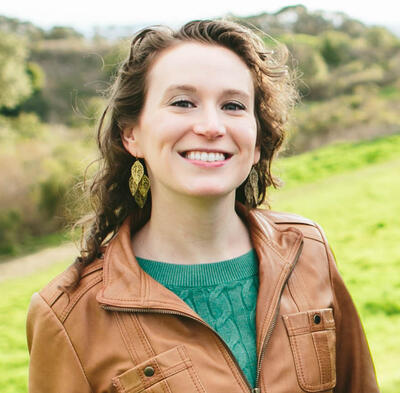 Headshot of person on a sunny hillside.